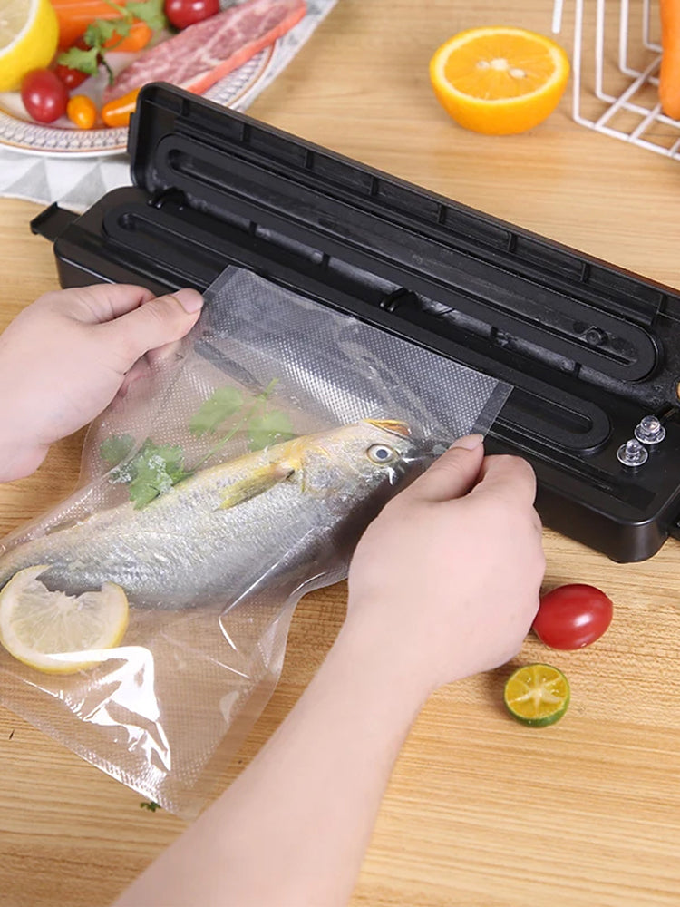 Hands sealing a bag of fish in the vacuum food sealer